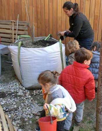 Els nens i nenes preparant l'hort.